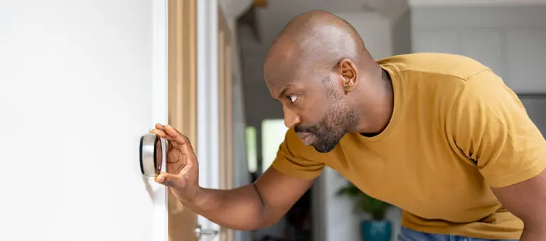 Man adjusting a thermostat
