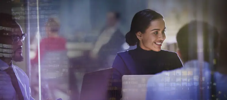People working on their laptops with the reflection of window lights