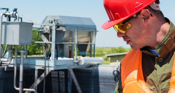 A photograph of an Engineer looking at a water treatment site