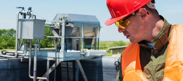 A photograph of an Engineer looking at a water treatment site