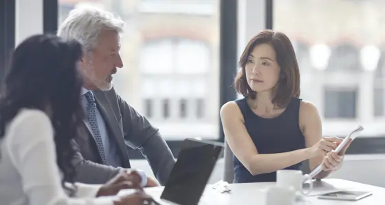 Businesswoman showing her notes to colleagues in a meeting