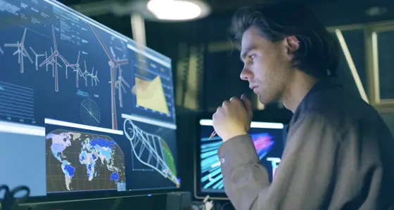 Worker looking at a screen with graphs and maps