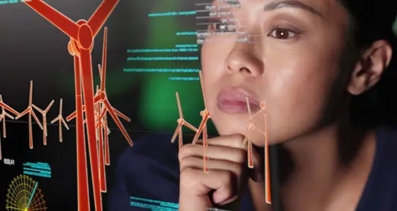 Woman looking at a screen showing data and models of wind turbines