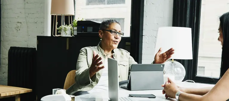 Two businesswomen having a discussion at a desk