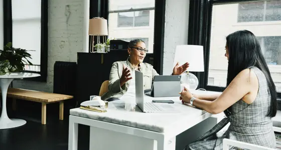 Two businesswomen having a discussion at a desk