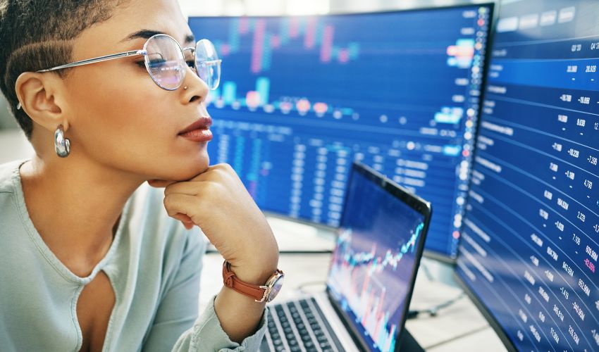 Woman looking at multiple monitors