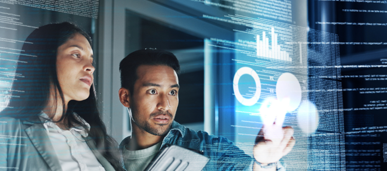 Two people looking at graphs on a transparent screen