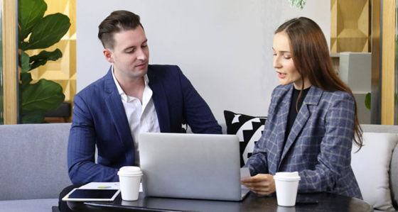 Two people around a laptop in a relaxed office environment