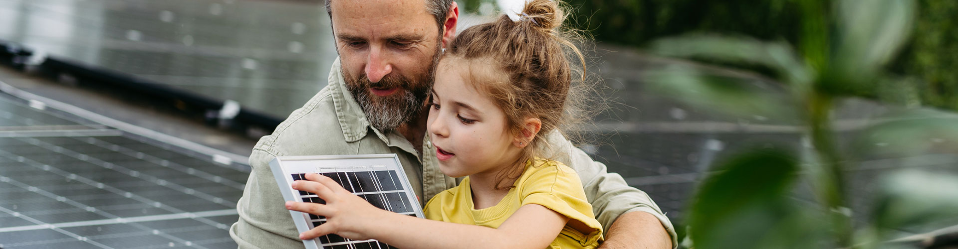 Father and daughter on the rooftop full of solar panels