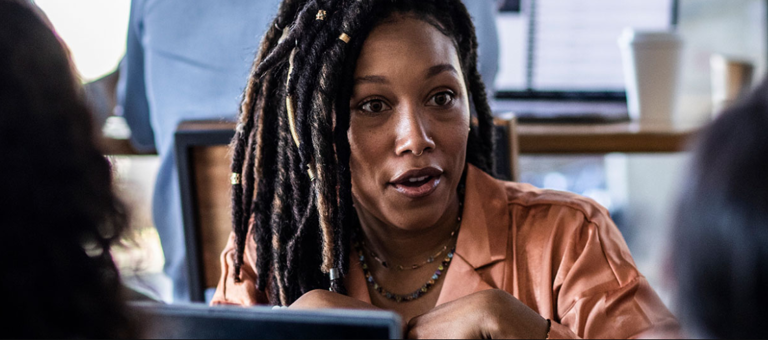 A black woman with her hair in braids in conversation