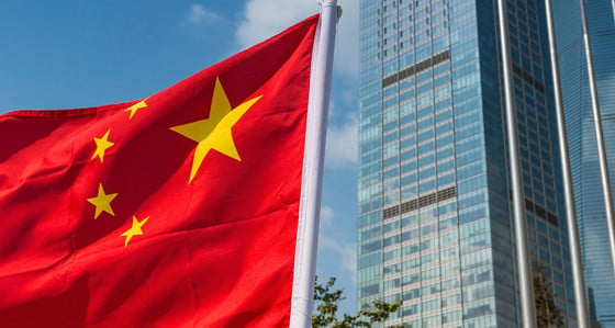 China Flag flying in front of skyscrapers