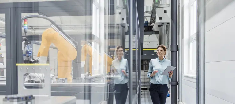 A woman with a clipboard in a manufacturing plant