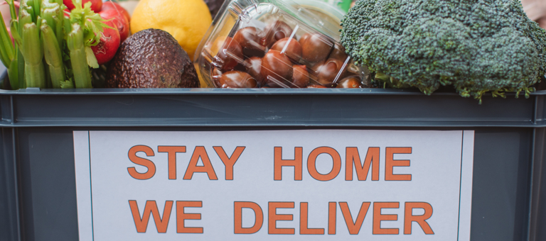A food basket full of vegetables with the slogan Stay Home We Deliver.