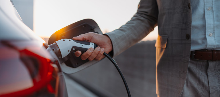 A man charging an electric vehicle