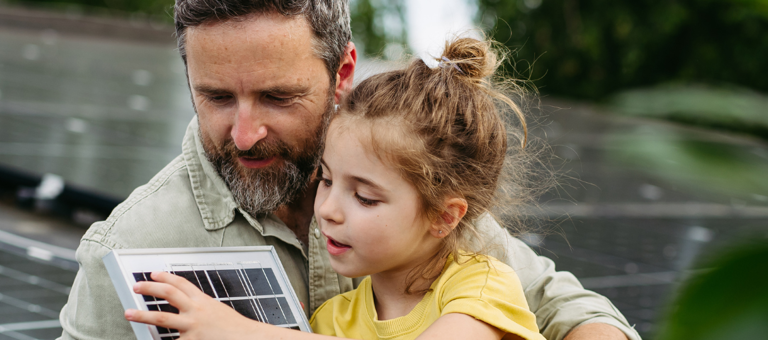 Father and daughter on the rooftop full of solar panels