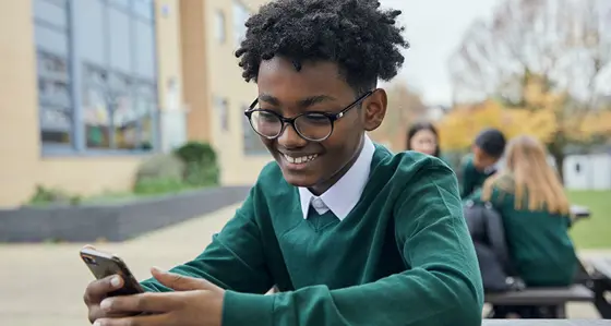Schoolboy looking at his smartphone