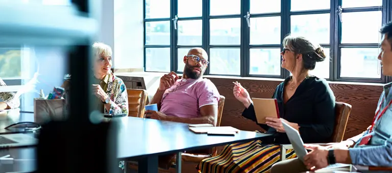 People sitting around a conference room table having a business meeting.
