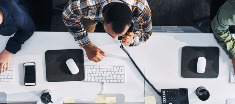 Three people seen from above working on their desks
