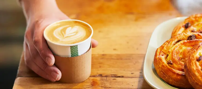 Close up of man's hand serving a coffee at a coffee shop
