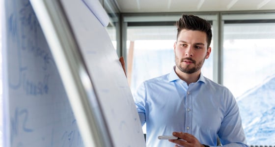 A man looking at a flipchart