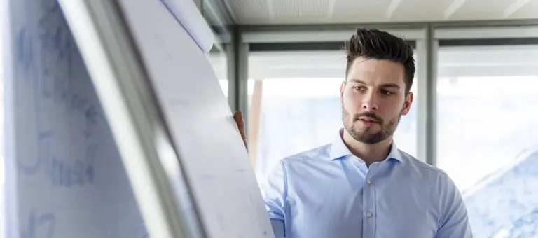 A man looking at a flipchart