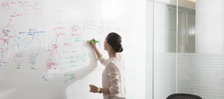 A woman writing on a whiteboard