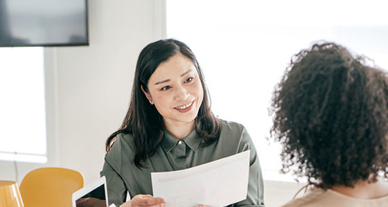 A women smiling and holding a report