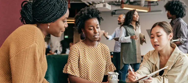 Three people having a discussion in the office