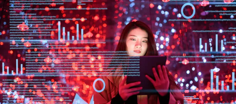 Woman using tablet with virtual screen of graphs and data surrounding her