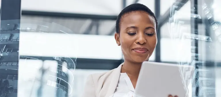 A woman looking at her tablet with reflections of modern buildings