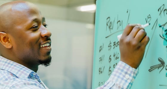 A man writing on a white board