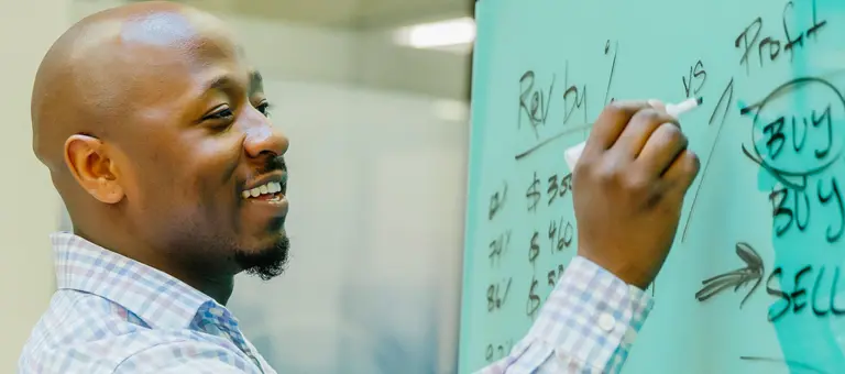 A man writing on a white board