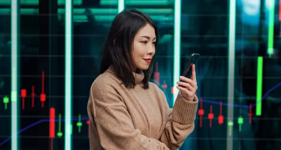 Young woman using her phone in front of backdrop