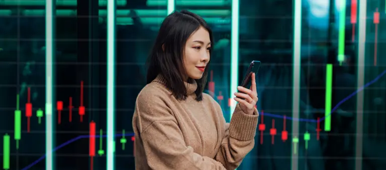 Young woman using her phone in front of backdrop