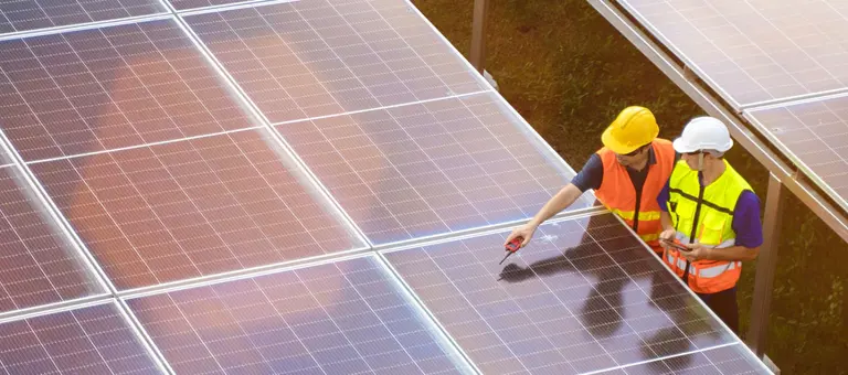 Workers inspecting a solar panel