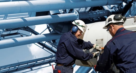 Two engineers working on pipework in an energy facility