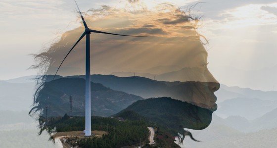 The head of a woman superimposed over a hillside with wind turbines