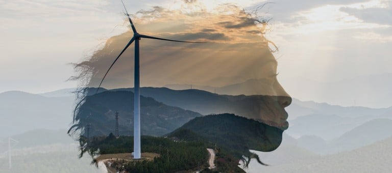 The head of a woman superimposed over a hillside with wind turbines