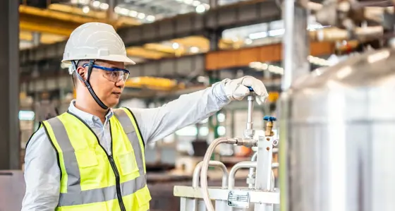 Asian worker operating a gas tank in a factory