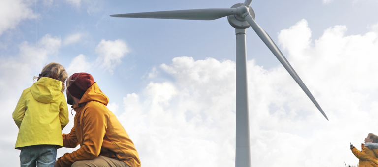 Father with his children in front of a wind turbine