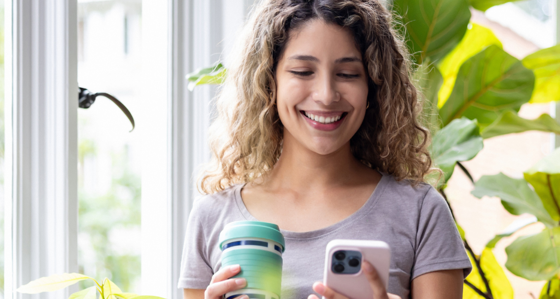 Happy woman looking at her home in a room with green plants