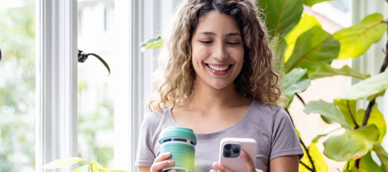 Happy woman looking at her home in a room with green plants
