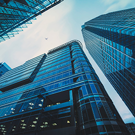 Looking up towards modern glass-fronted buildings