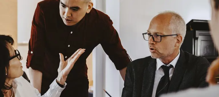 Three people having a discussion during a meeting