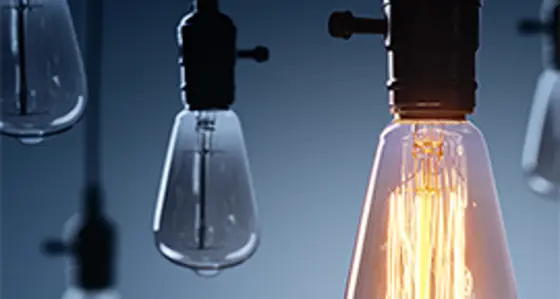 A collection of light bulbs with one illuminated