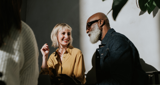 Conceptual image of a man and a woman sitting side-by-side in a sunny, modern environment