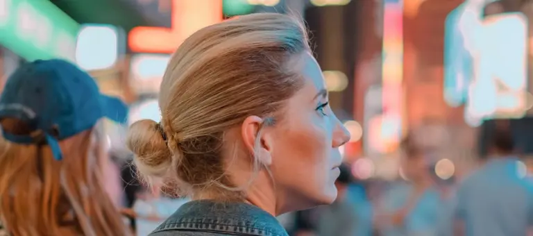 Woman stood in the city surrounded by advertising screens