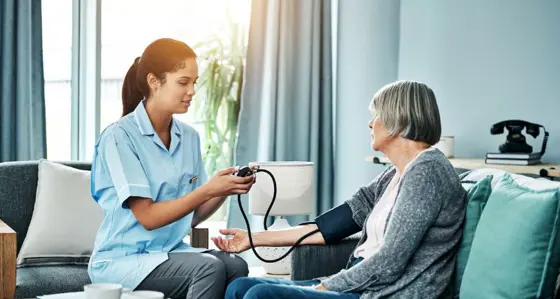 Nurse checking an elderly woman's blood pressure