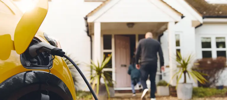 electric car charging on driveway outside house