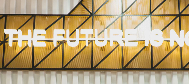 An illuminated sign with the slogan 'The Future Is Now'